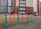 Children run on the street past swings on the Playground in the courtyard of an apartment building covered with striped tape close