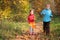 Children run on wood autumn footpath