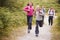 Children running ahead of parents, walking on a country path during a family camping trip, front view, close up