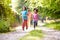 Children Running In Countryside With Father