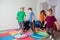 Children running and jumping around multicolor hoops on a floor