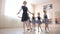 Children's ballet school. Caucasian woman teaching ballet to little girls.