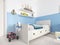 Children`s bedroom with a white bed in the room and a shelf with