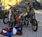 Children`s bicycles parked in the rack and multicolored helmets r