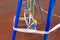 Children\\\'s blue swing on a sports playground in the park wrapped with red barrier tape