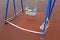 Children\\\'s blue swing on a sports playground wrapped with red barrier tape