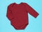 Children`s bodysuit with long sleeves of burgundy color on a blue background, top view