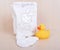 Children`s clothing diapers pajamas mittens socks vests sliders white background and ruber toy yellow duck