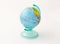 Children`s coin box for money made in the form of a globe planet Earth with a slot for money at the top on a white backg