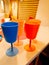 Children`s colored plastic tableware, blue, pink and orange glasses for party and birthday party.
