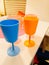 Children`s colored plastic tableware, blue, pink and orange glasses for party and birthday party.