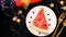 Children`s creative feet Christmas food. A slice of watermelon decorated in the shape of a Christmas tree lies on a