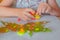 Children& x27;s creativity at home. Little girl makes a toy from bright plasticine on the background of autumn crafts from