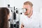 Children`s doctor examining little girl with ophthalmic equipment