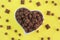 Children`s dry chocolate breakfast pillows and balls in a ceramic plate in the shape of a heart on a yellow background