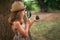 Children& x27;s education. Pretty little girl scout in a straw hat looks at pine cone through magnifier. The concept of