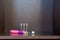 Children`s electric pink toothbrush with backlight with three interchangeable nozzles lies on a dark shelf