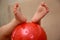 Children`s feet on the ball. Baby feet on the ball. Small baby feet