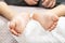 Children`s feet covered with white powder lie on a white towel. Talc on the skin of the child`s feet.