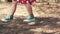 Children`s feet walking toward in park path.