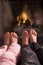 Children\'s feet warming at a fireplace