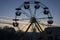 Children`s Ferris wheel against the sunset sky