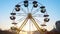 Children`s Ferris wheel with cabs and umbrellas