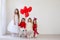 Children`s friends sit with red balloons at the holiday birthday