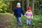 Children`s friendship. Children stand together and hold hands in the autumn park. Little boy and girl friends