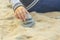 Children`s hand builds a tower of stones on the yellow sand2