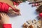 Children`s hand writes with a pencil. Child`s hands, the sheet of paper, pencils and Christmas decorations on a wooden