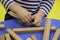 Children`s hands collect a wooden constructor. children`s puzzle puzzle of wooden parts. child plays and develops with wooden el