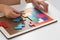 Children`s hands collect a wooden multi-colored geometric puzzle on a white table, the concept of child development and board