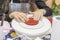 Children\'s hands create first layer of future red shortbread bento cake on white platform. Master class in culinary arts.
