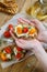 Children`s hands hold a bruschetta with ricotta cheese and sun-dried tomatoes with Provencal herbs.