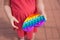 Children& x27;s hands hold a silicone toy. Kids being kids LGBTQ colors