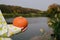 children& x27;s hands holding an orange pumpkin on the river Bank. Halloween