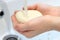 Children`s hands holding soap under running water under bathroom sink faucet