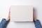 Children`s hands holds white cardboard box on white background. Top view. Shipping concept