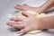 Children`s hands knead a piece of dough