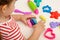 Children`s hands with multicolored plasticine, play dough on white table