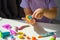 Children`s hands with plasticine turtle on white table at home, children`s motor skills development games, children with