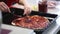 Children`s hands prepare pizza. spread the filling on the dough.