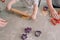 children s hands roll out the dough on the table with a rolling pin top view close up