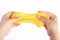 Children`s hands stretch homemade goo and yellow slime. White background. White background
