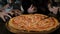 Children`s hands taking pizza slices from wooden table