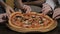 Children`s hands taking pizza slices from wooden table