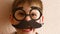 Children`s humor on the topic of strictly papf. A funny Caucasian preschooler grimaces shows holding glasses with a mustache in fr