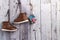 Children\\\'s leather demi-season boots hang on a gray wooden wall. Space for text