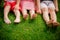 Children`s legs on the grass. bare legs of little girls sitting on the meadow. children sit on the grass with bare legs